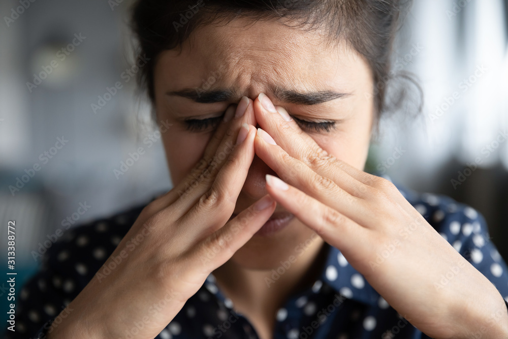 Sick frustrated young indian woman cope with headache, face closeup Sick frustrated young indian woman cope with headache, face closeup