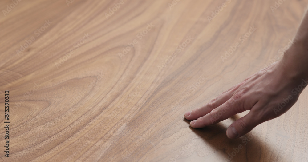 man hand touches black walnut dining table surface - obrazy, fototapety, plakaty 