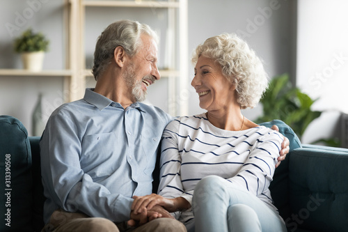 Grandfather and grandmother holding hands chatting laughing spend time together © fizkes