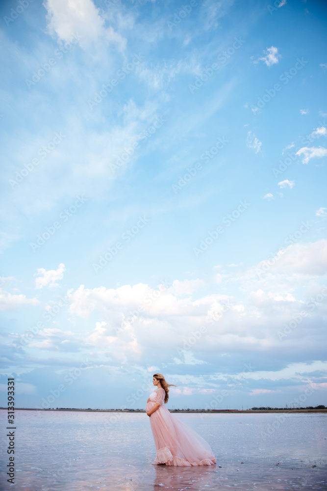 beautiful young pregnant woman enjoying the sun on the beach, pink lake beautiful young pregnant woman enjoying the sun on the beach, pink lake