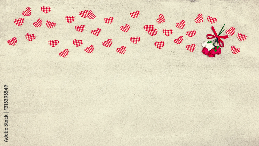 Small textile hearts and flowers on concrete surface with copy space. Romantic vintage widescreen background