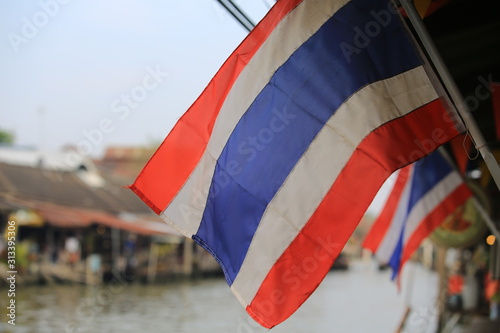 waving Thailand flag at outdoor with water market background