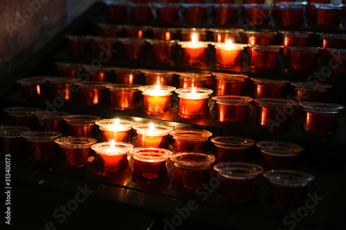 Rows of burning candles in a dim church photo