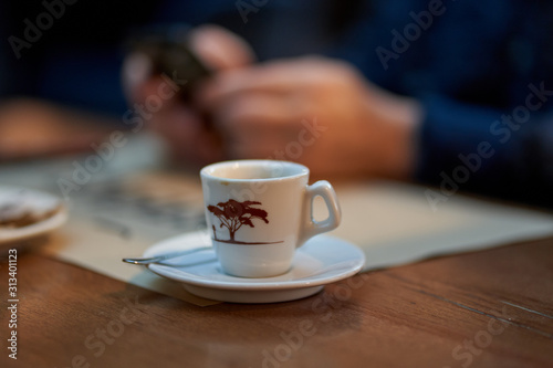 Coffee cup and man using cellphone