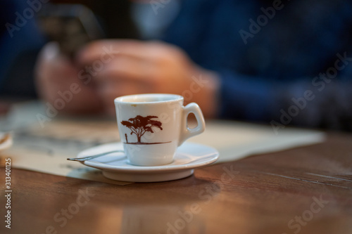 Coffee cup and man using cellphone