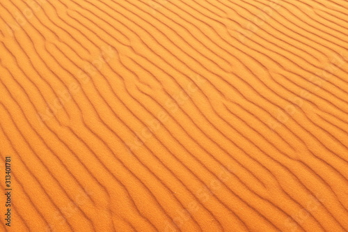 Bright orange rippled desert sand for a warm and vibrant summer background