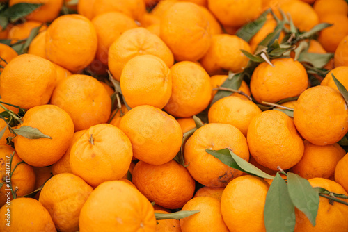 Beautiful selected organic tangerines background, ripe tangerines, lots of tangerines on a market counter.