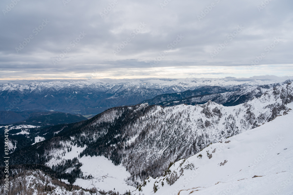 Spectacular winter mountain panoramic view of mountains with clouded sky.