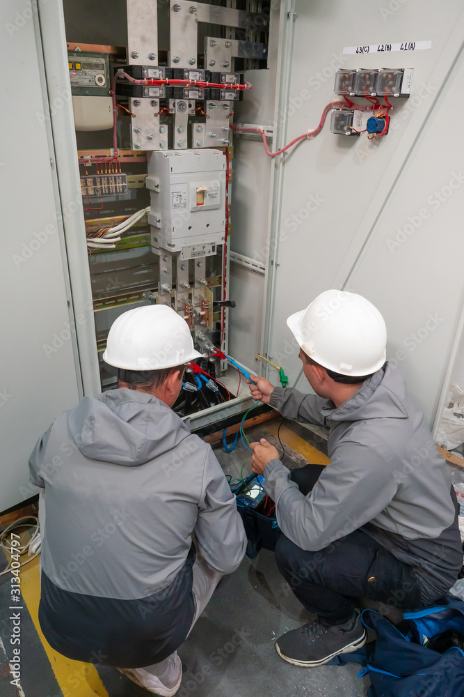 Electricians take measurements. Worker in uniform. Electricians take measurements. Worker in uniform.