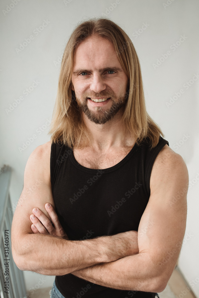 Portrait of man with long blond hair looking in camera. Closeup portrait of young boy. Brutal bull with amazing eyes and white teeth smiling Portrait of man with long blond hair looking in camera. Closeup portrait of young boy. Brutal bull with amazing eyes and white teeth smiling