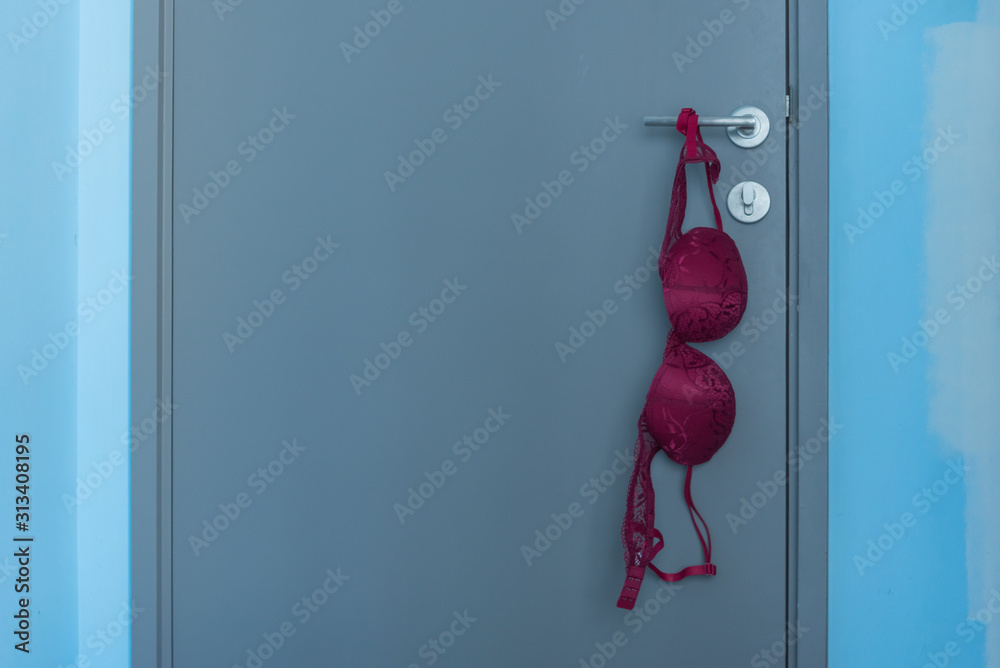 red woman bra hanging on the door knob Stock-Foto | Adobe Stock