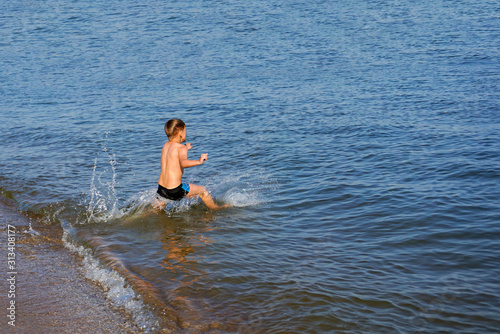 The boy jumps and dives into the sea.
