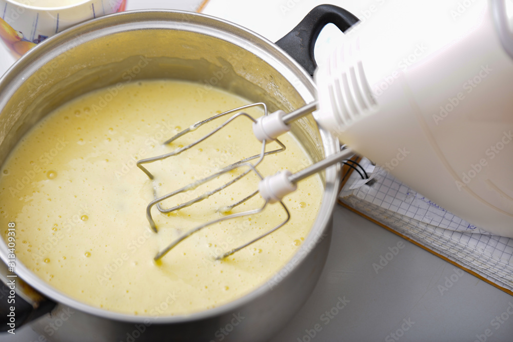 Fototapeta premium An electric mixer stirs and whips the dough to bake a pie.