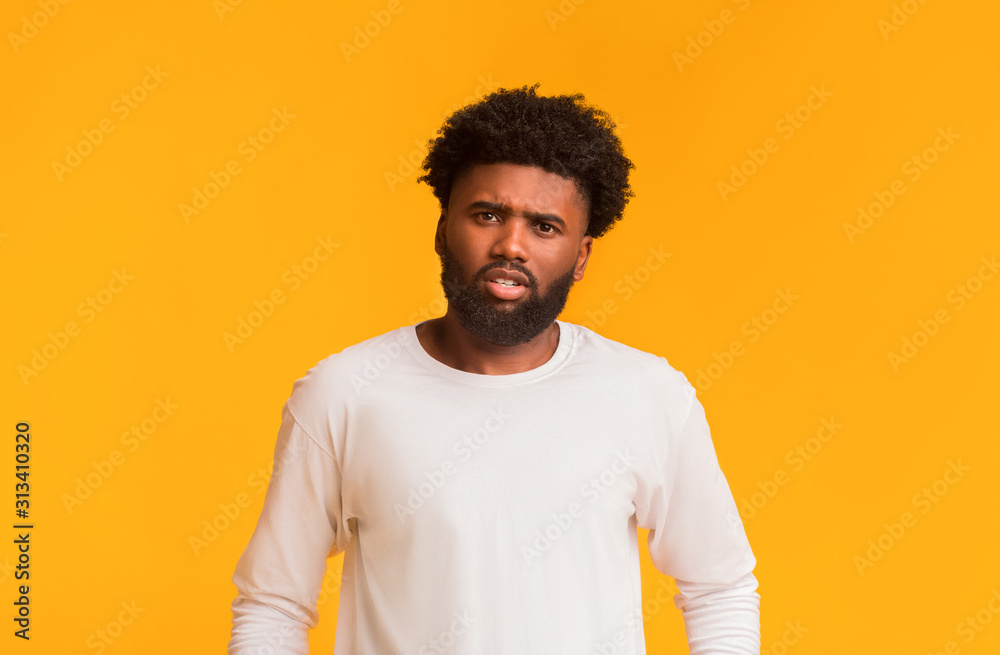 Indignant young afro man over orange background Indignant young afro man over orange background