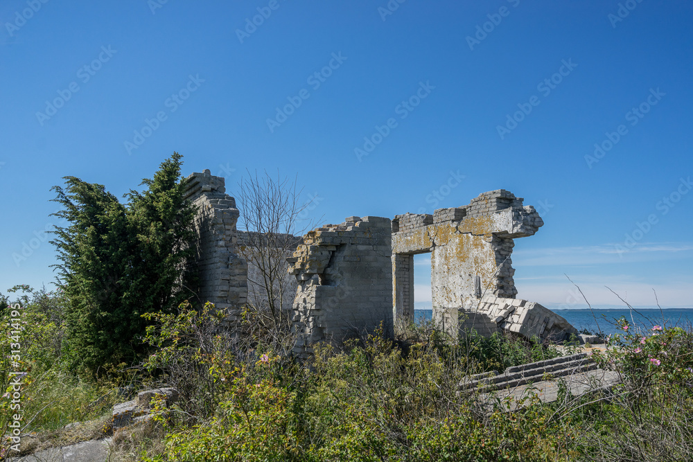 Fototapeta premium Abandoned houses in the Baltic Sea. Shore, nature and military ruins facilities architecture concept. Harilaid, small island in Estonia, Europe.