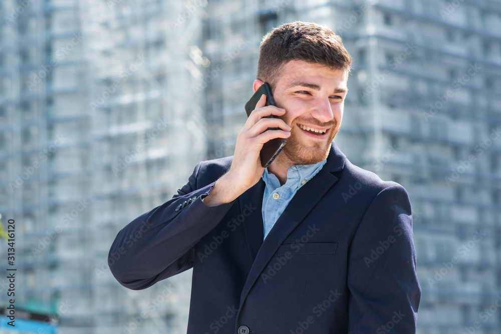 Close up happy young businessman talking with cellphone in city Close up happy young businessman talking with cellphone in city