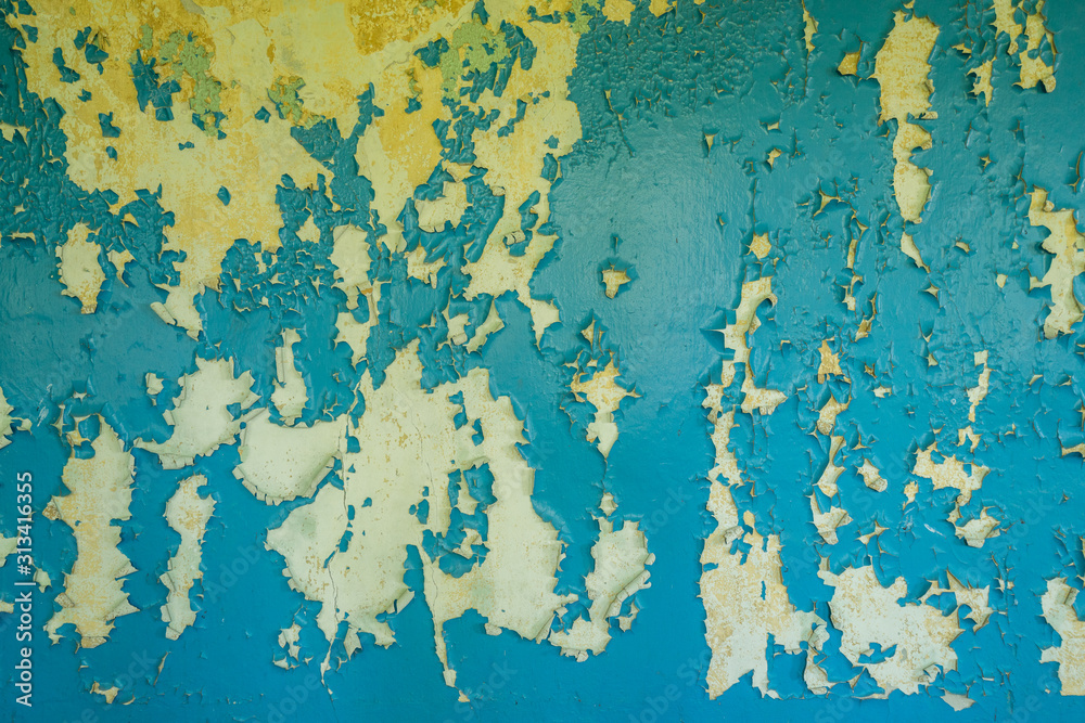 Colorful cement stone wall. Cracked wall with old layers of paint in abandoned house