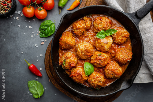 Meatballs with spicy tomato sauce on a frying pan, view from above, top view