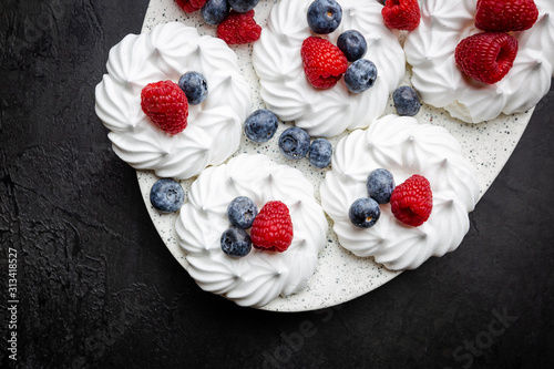 White meringues cakes with berries, raspberry and blueberry. Flat lay, top view
