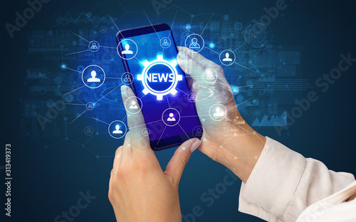 Female hand holding smartphone with NEWS abbreviation, modern technology concept