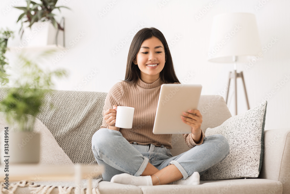 Cheerful girl reading e-book on digital tablet Cheerful girl reading e-book on digital tablet