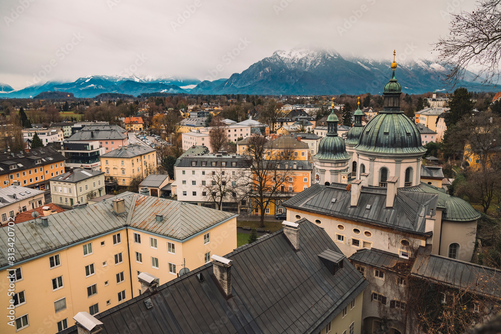 old European city Salzburg in Austria urban top view landmark with living buildings and cathedral church foreground, snowy peaks of Alps mountain ridge landscape background scenic view