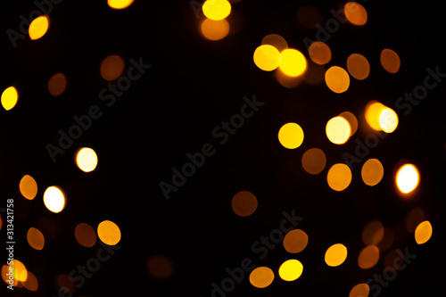 Bright golden glitter festive background. Abstract shimmering circles decorative backdrop. Bokeh lights with shiny effect. Overlapping glowing and twinkling spots