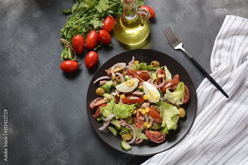 Tuna salad with lettuce, eggs and tomatoes, cucumber, corn and red onion. Healthy Mediterranean food concept photo