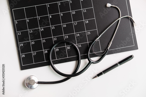 Stethoscope with calendar, medical appointment reminder and annual checkup concept, Top view