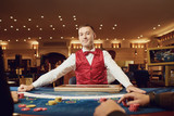 Croupier holds poker cards in his hands at a table in a casino.