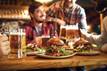 Burger with beer on the table in a bar pub.