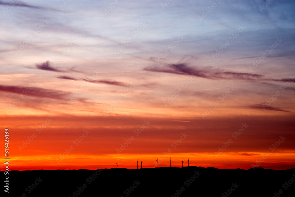 Roter sonnenuntergang vor einem windpark