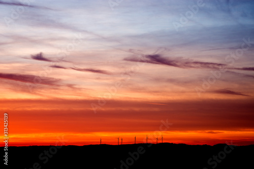 Roter sonnenuntergang vor einem windpark