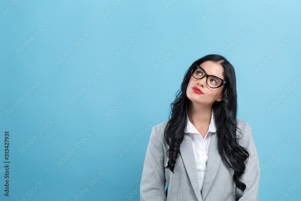 Young woman in a thoughtful pose on a blue background Young woman in a thoughtful pose on a blue background