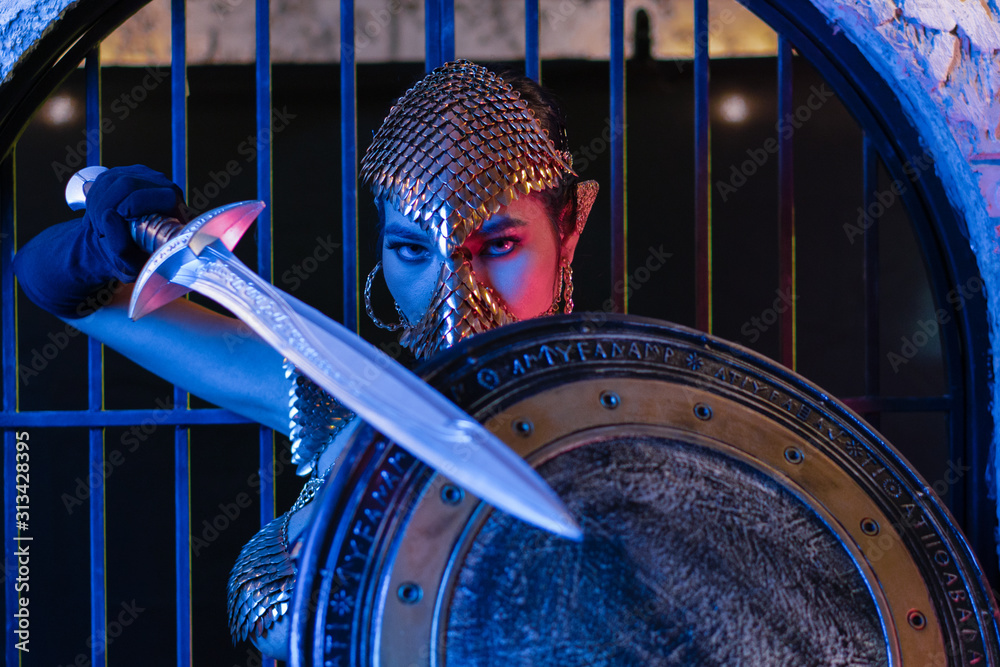 nude art portrait of asian woman in fantasy warrior costume with sword in colorful background