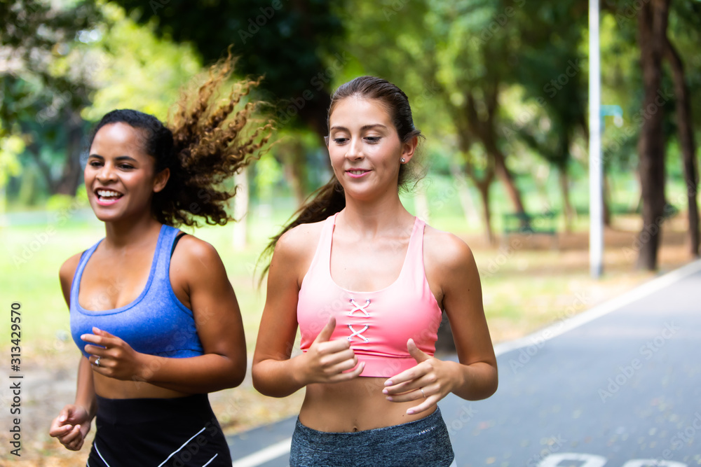 two sports woman running at health park. Black african american and friends in sports clothing running while hovering against. Happy good healthy and wellness concept. lifestyle concept.