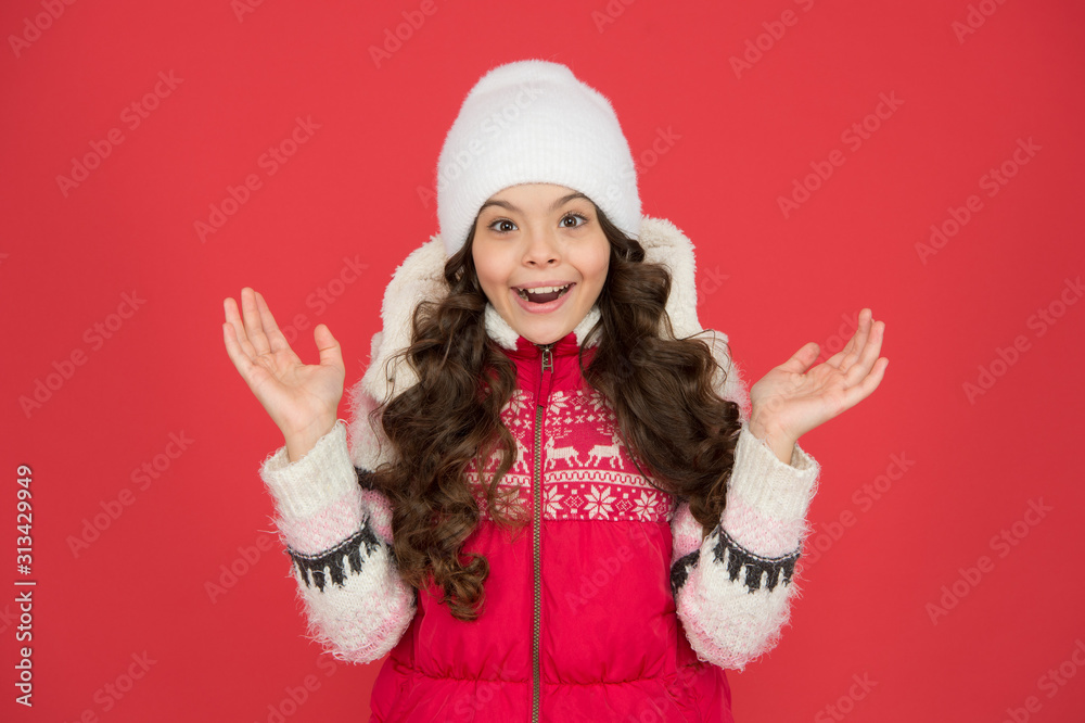 surprised about winter sales. portrait of pure beauty. small girl long curly hair. its cold outside. winter outfit for kids. happy childhood. child in knitted hat. feeling cosy in warm clothes surprised about winter sales. portrait of pure beauty. small girl long curly hair. its cold outside. winter outfit for kids. happy childhood. child in knitted hat. feeling cosy in warm clothes