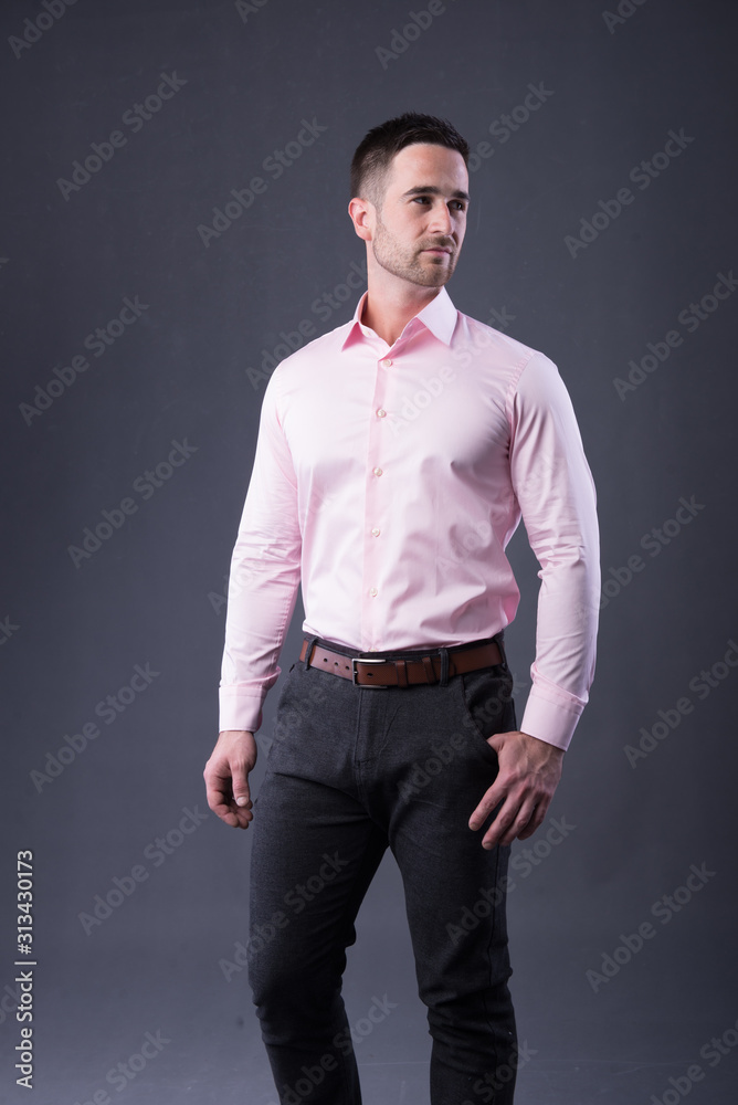 young man in a pink shirt and dress pants