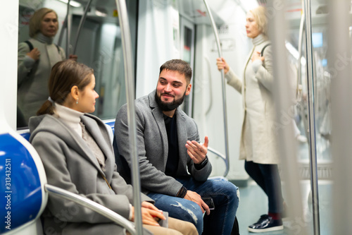 Portrait of playful positive people making acquaintance in public transport