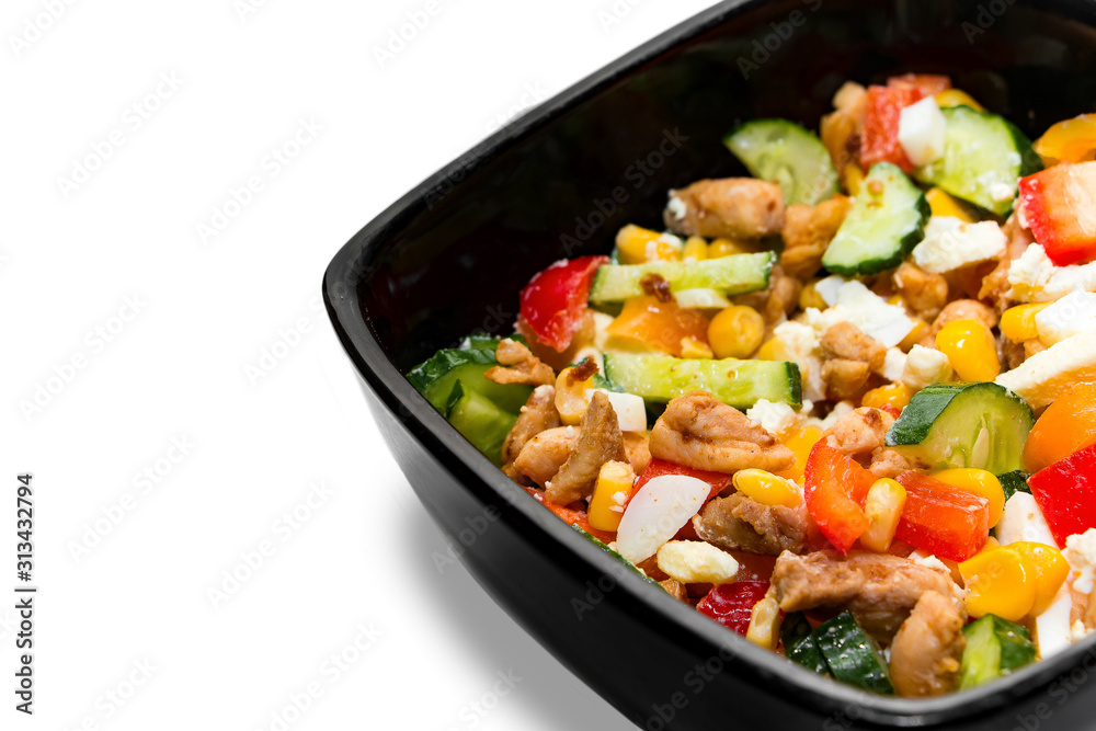 Tasty vegetable salad with chicken in a black plate Isolated on white background