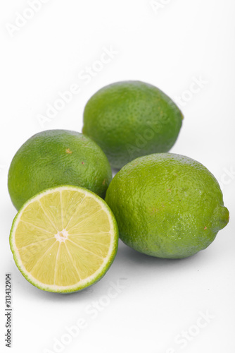 Fresh lime, half and quarter part on white background. Green citrus fruit. 
