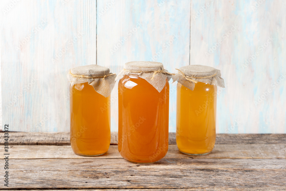 Kombucha tea in glass canister on wooden background Kombucha tea in glass canister on wooden background