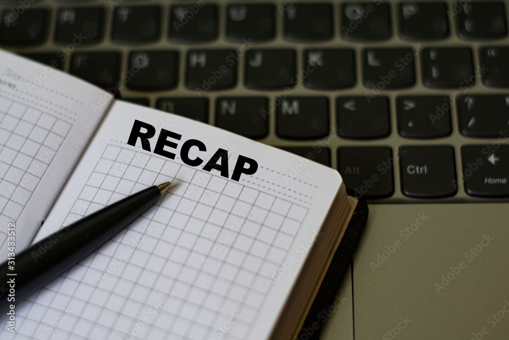 notebook with the word recap, on the background of a laptop notebook with the word recap, on the background of a laptop