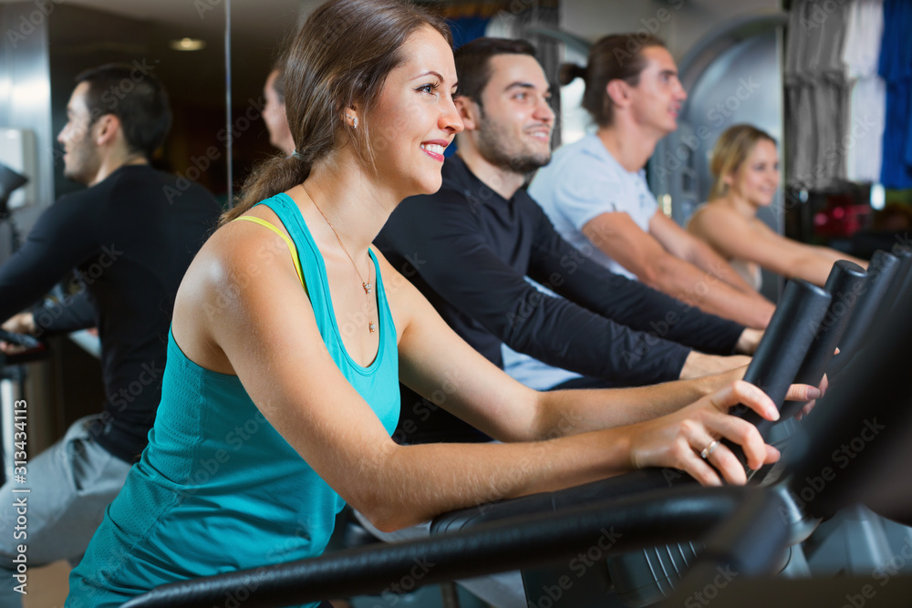 Group positive working out of cycling in fitness club