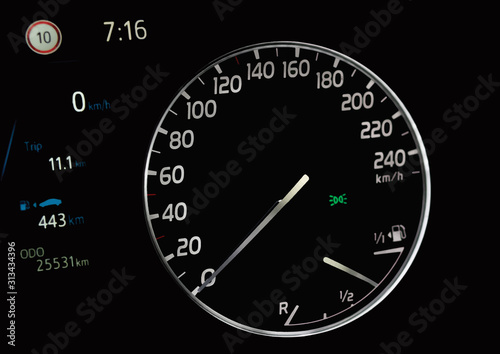 Illustration of side view of car dashboard with circular speedometer, fuel gauge indicator, odometer, trip distance, fuel range and parking lights icon. Petrol level showing on car instrument panel.