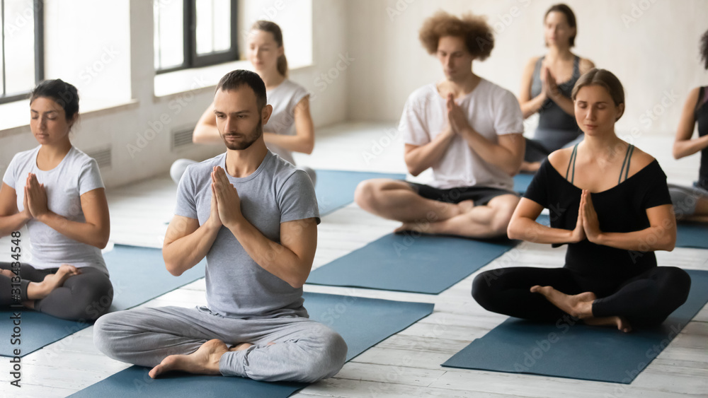 Group of diverse young people practicing yoga, doing Padmasana exercise