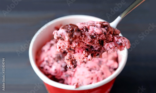 Billede på lærred Closeup a spoon scooping delectable strawberry chocolate chunk ice cream