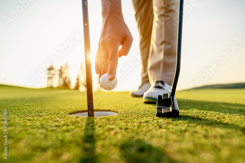 lifestyle, golf, activity, outdoor, sport, golfer concept. Golfers collect golf balls that hole in the green grass on the golf course in the morning.