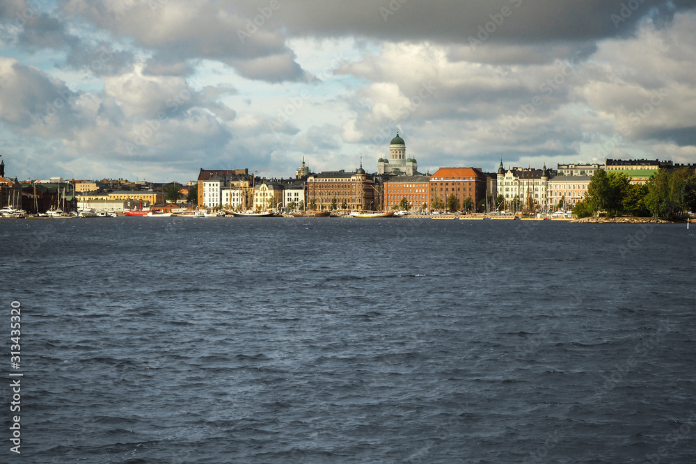 View of the waterfront of Helsinki, Finland, seen from the Baltic Sea with a dramatic cloudy sky