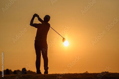 lifestyle, golf, activity, outdoor, sport, golfer concept A man is sweeping golf on the sand at a golf course at sunset in the summer. Sport lifestyle Concept.